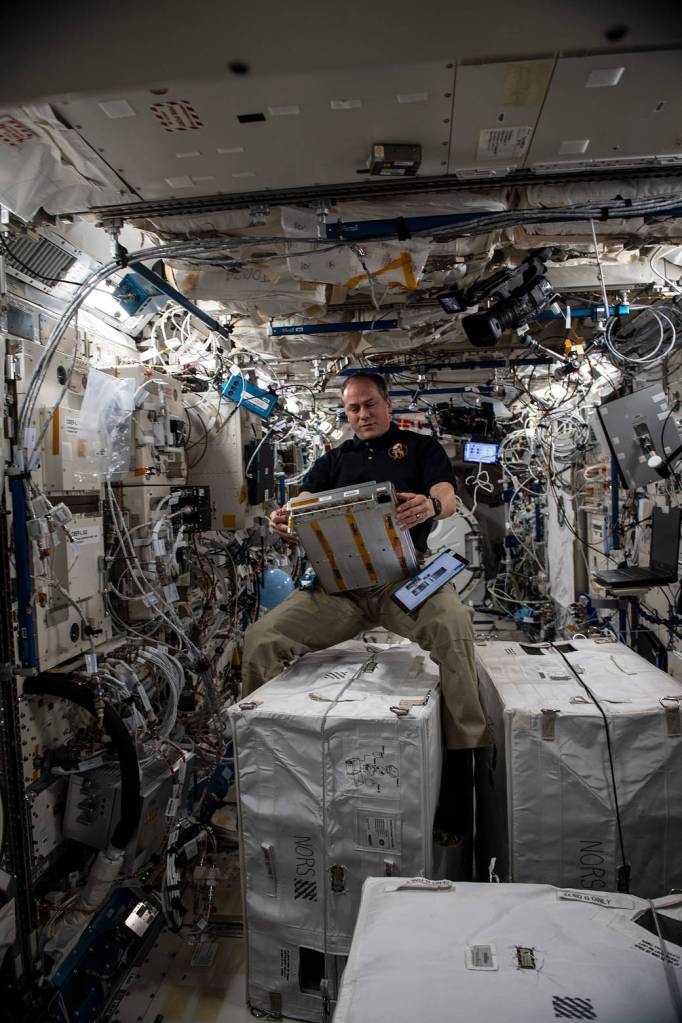 Astronaut Tom Marshburn services components on a unique incubator
