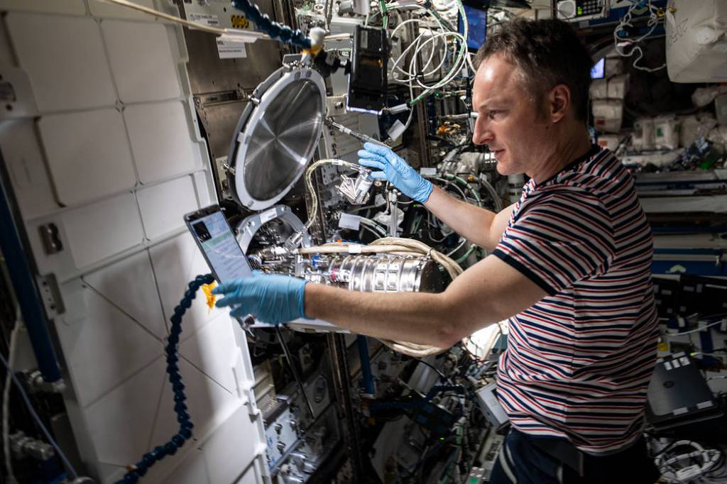 Astronaut Matthias Maurer works on combustion research hardware