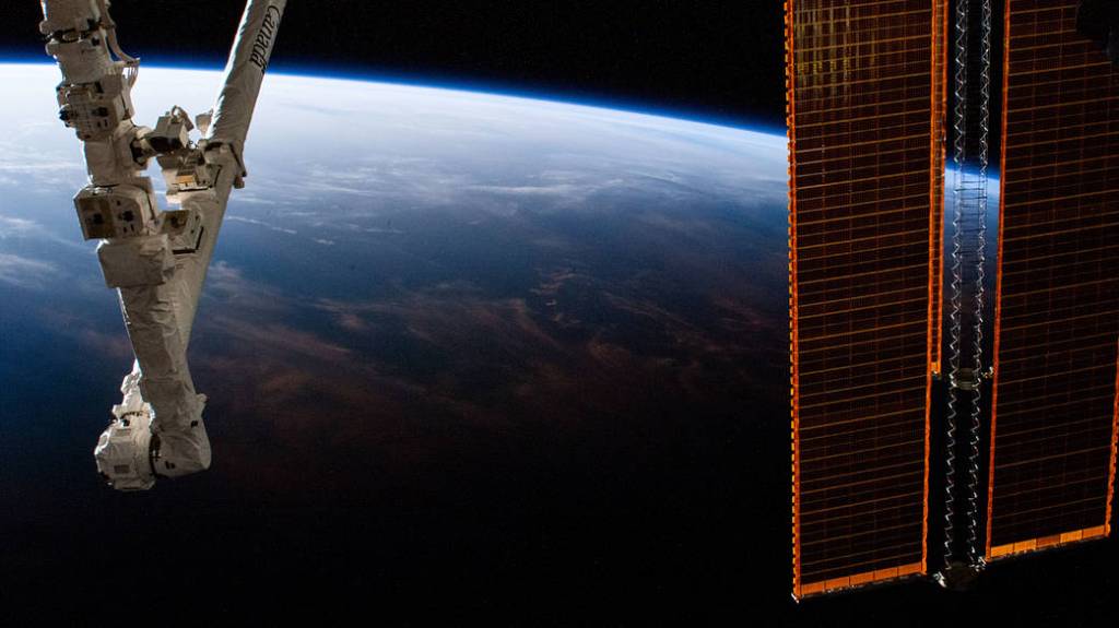The space station orbits into a sunrise above the Pacific Ocean