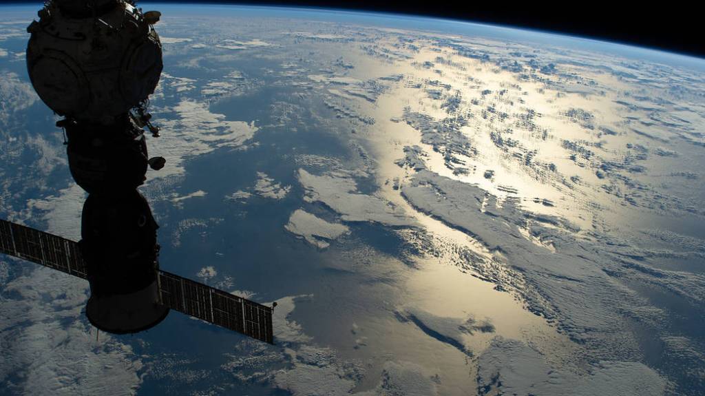 The silhouetted Soyuz MS-21 crew ship above the Pacific Ocean