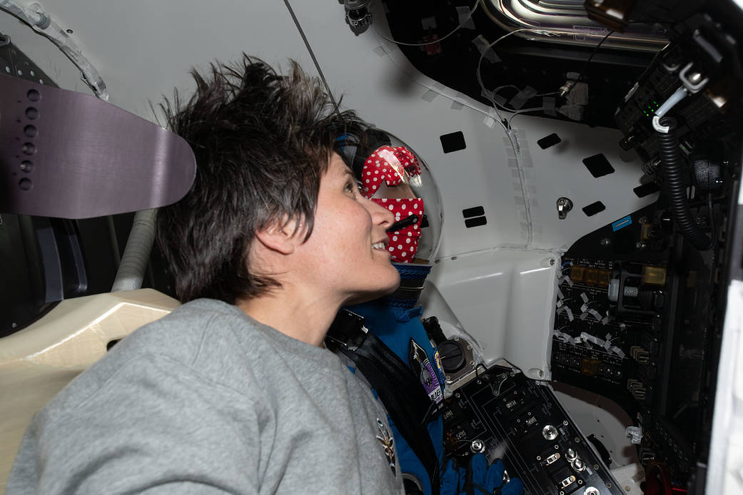 Astronaut Samantha Cristoforetti is seated next to "Rosie the Rocketeer"