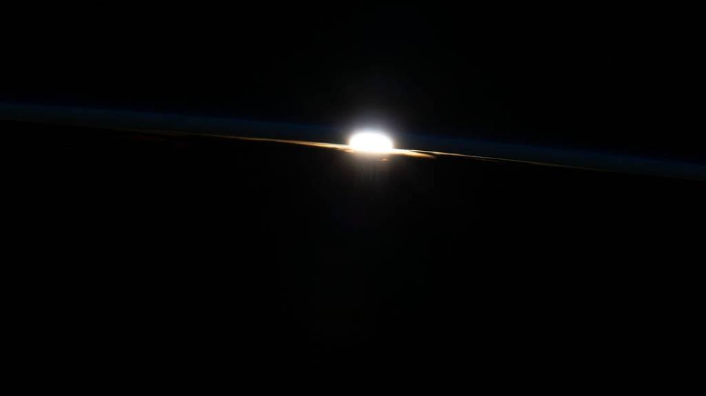 The last rays of an orbital sunset burst through Earth’s horizon