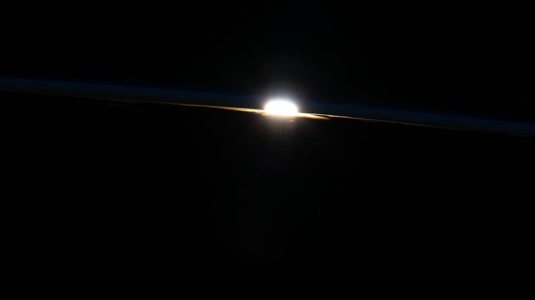 The last rays of an orbital sunset burst through Earth's horizon