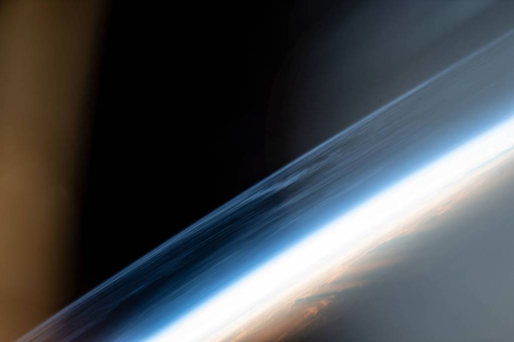 Wispy, noctilucent clouds blanket the Earth’s horizon