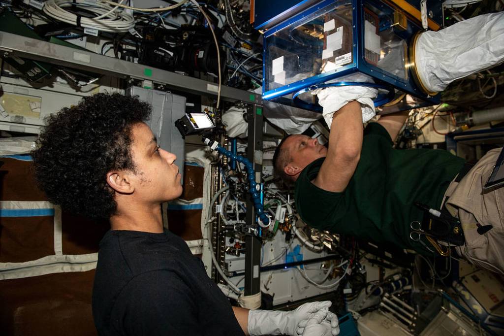Astronauts Jessica Watkins and Bob Hines transport research gear