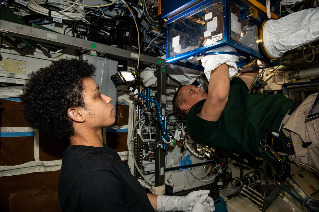 Astronauts Jessica Watkins and Bob Hines transport research gear