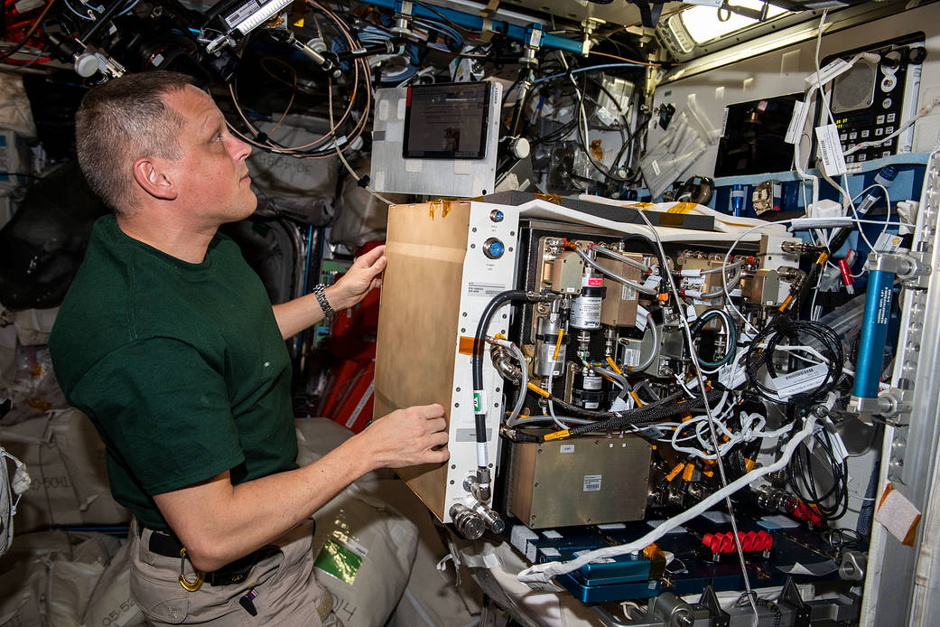 Astronaut Bob Hines works on the Plant Habitat's growth chamber