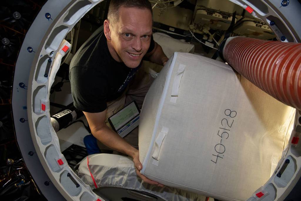 Astronaut Bob Hines packs cargo inside the SpaceX Dragon
