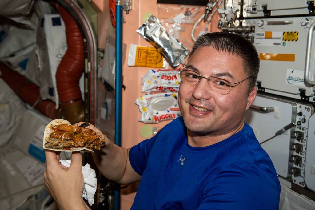 NASA astronaut Kjell Lindgren enjoys a taco at dinner time
