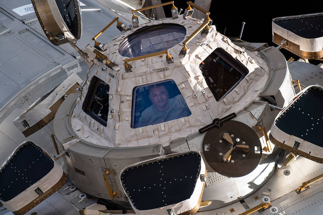 Astronaut Kjell Lindgren looks out from a window on the cupola