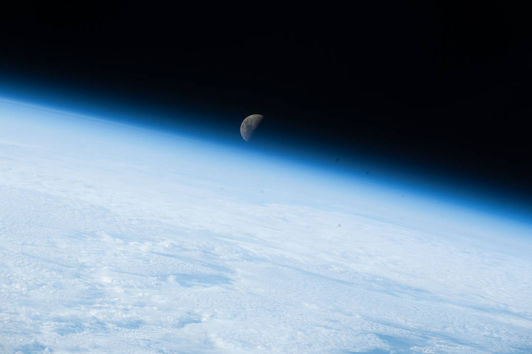 The first quarter Moon sets below Earth's horizon