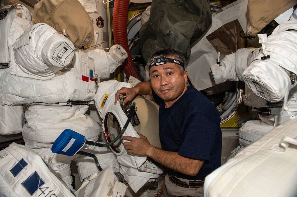 Astronaut Koichi Wakata works on spacesuits in the Quest airlock