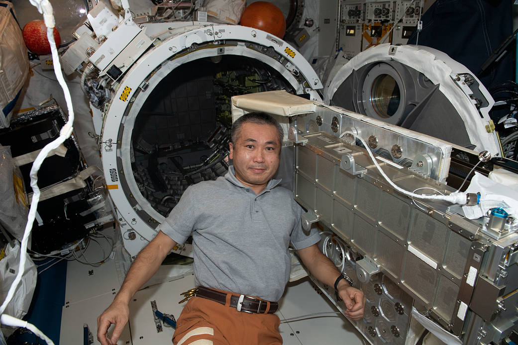 Astronaut Koichi Wakata works on a small satellite orbital deployer