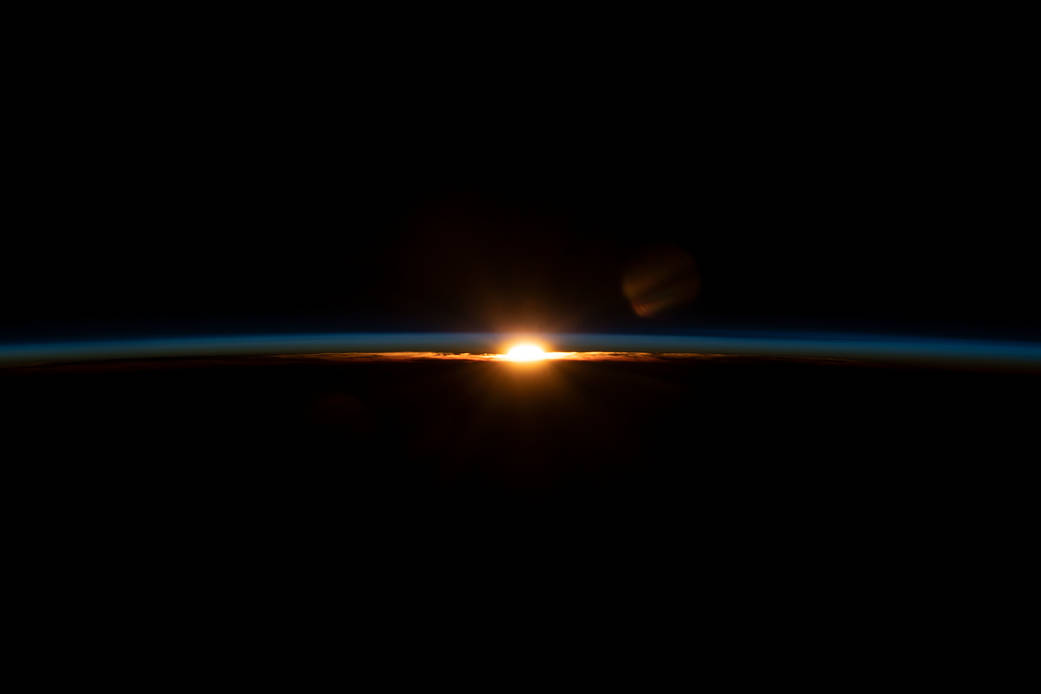 The sun's last rays illuminate Earth's thin atmosphere