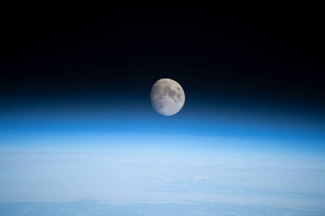 The waxing gibbous Moon above Earth's horizon