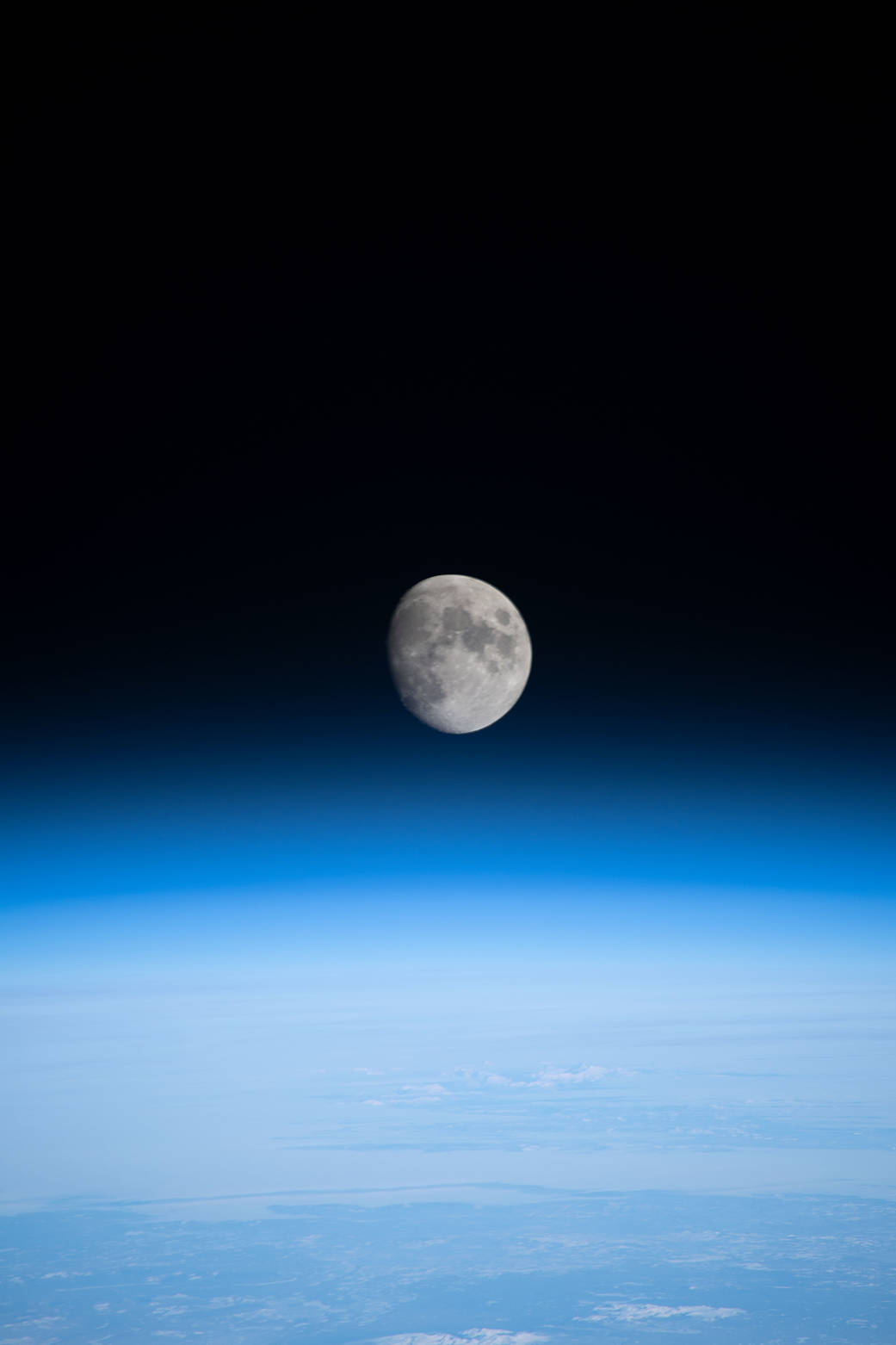 The waxing gibbous Moon above Earth's horizon