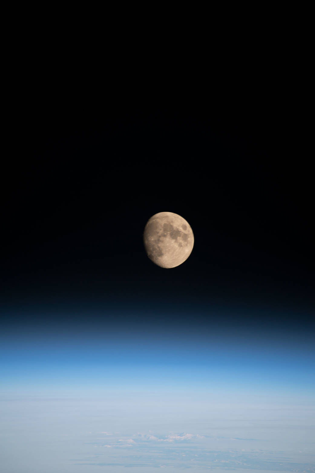 The waxing gibbous Moon above Earth's horizon