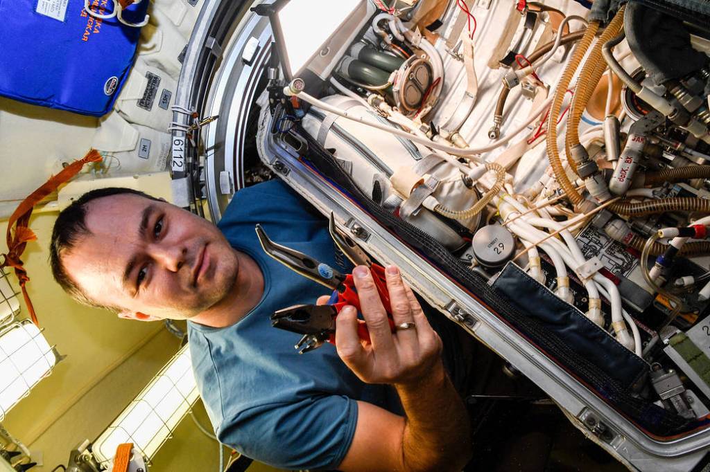 Cosmonaut Dmitri Petelin works on an Orlan spacesuit