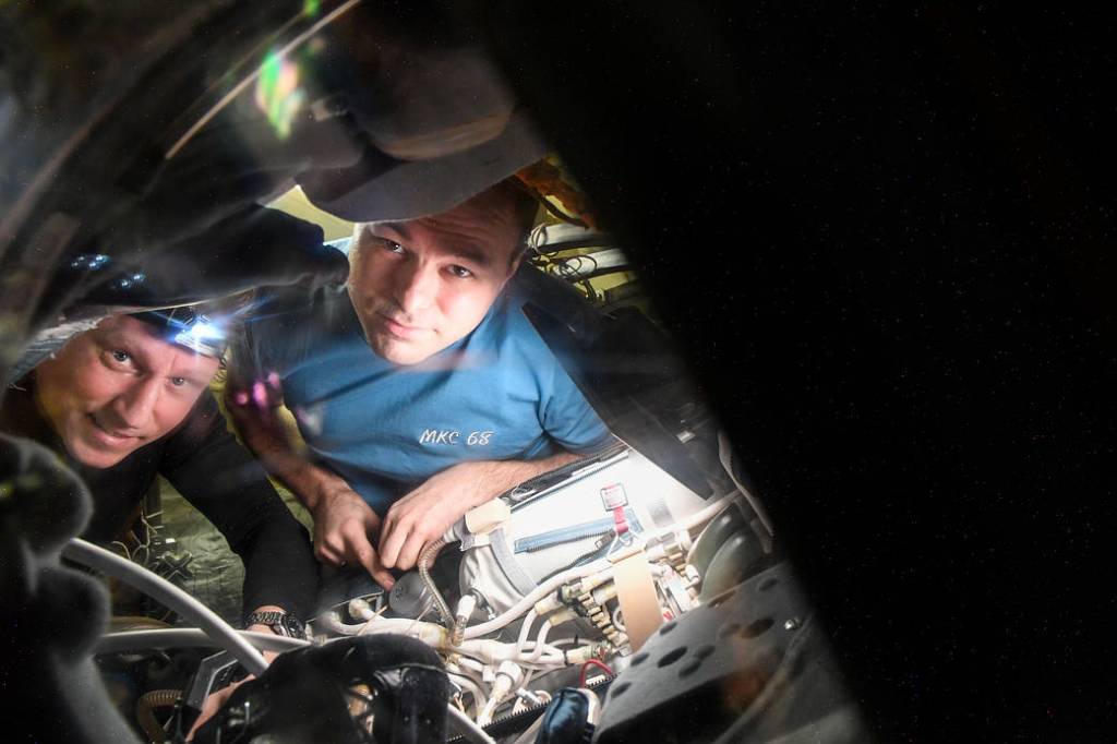 Cosmonauts Sergey Prokopyev and Dmitri Petelin work on an Orlan spacesuit
