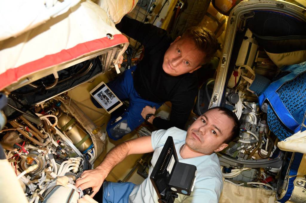 Cosmonauts Sergey Prokopyev and Dmitri Petelin work on an Orlan spacesuit