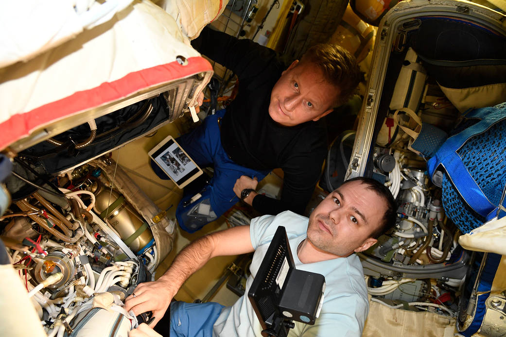 Cosmonauts Sergey Prokopyev and Dmitri Petelin work on an Orlan spacesuit