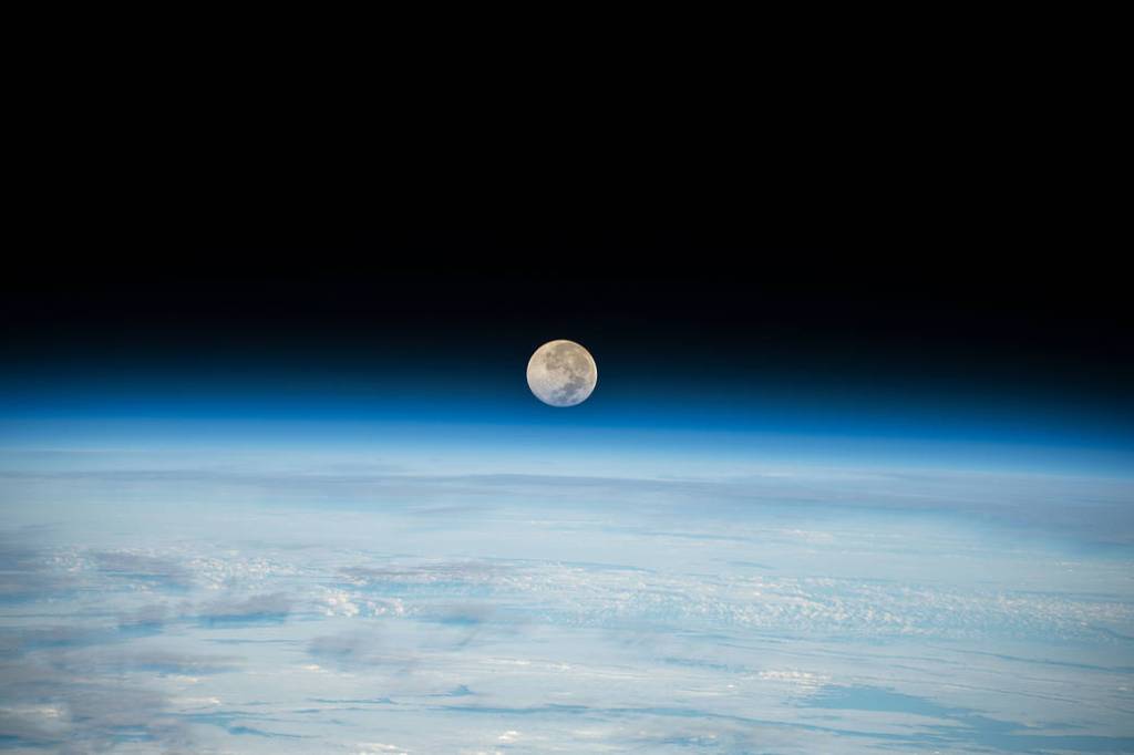 The Full Moon is pictured setting below Earth’s horizon