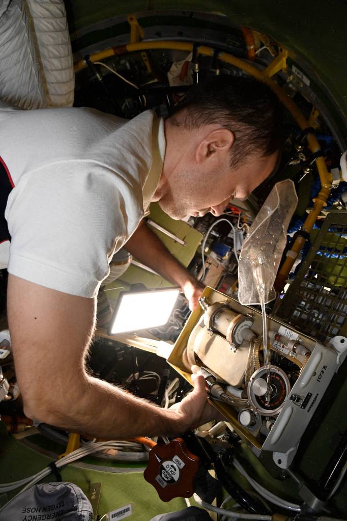 Cosmonaut Dmitri Petelin services Orlan spacesuit components