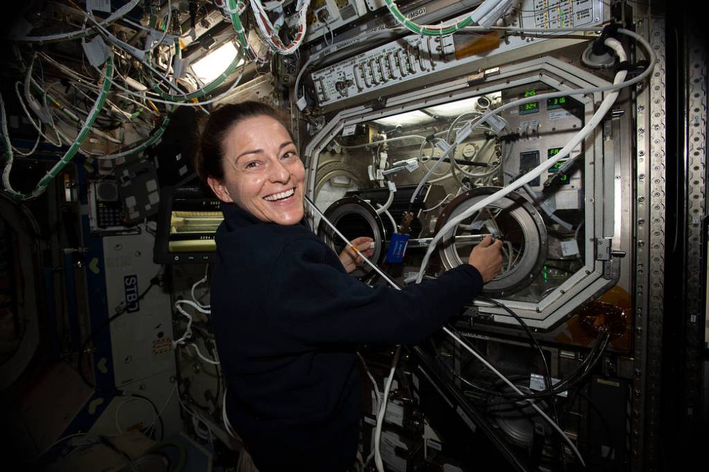 Astronaut Nicole Mann exchanges samples for a space physics study
