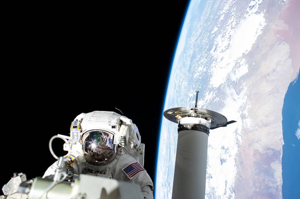 NASA spacewalker Josh Cassada works on a roll-out solar array