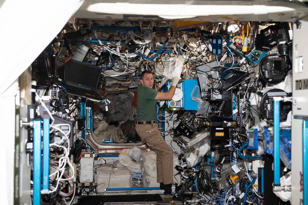 NASA astronaut Josh Cassada is pictured cleaning hardware