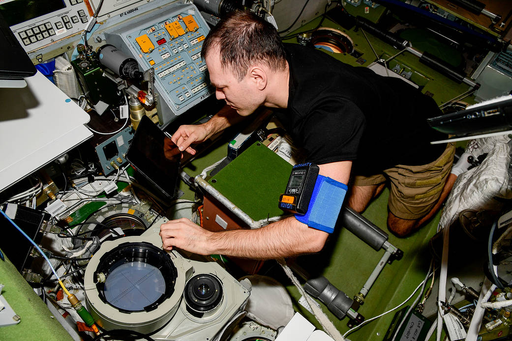 Cosmonaut Dmitri Petelin configures optical hardware