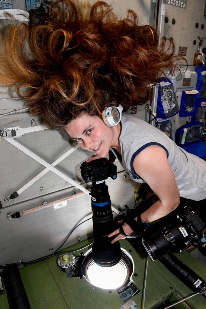 Cosmonaut Anna Kikina points a camera outside a space station window