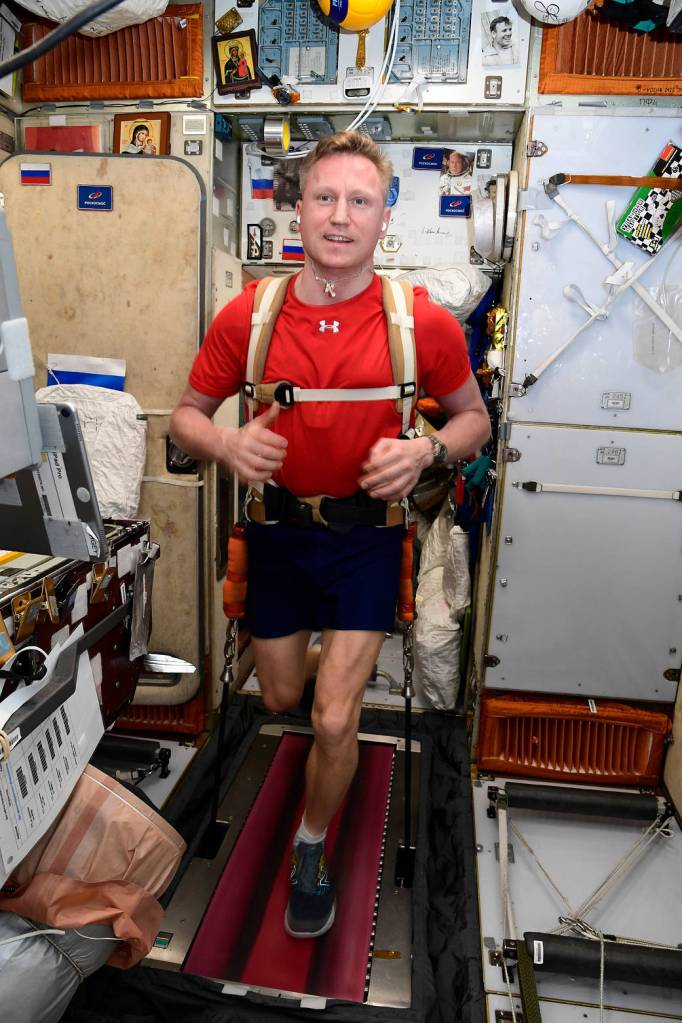 Cosmonaut Sergey Prokopyev jogs while tethered to a station treadmill