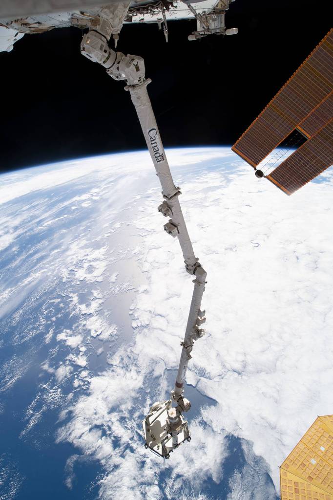 The Canadarm2 robotic arm extends away from the space station