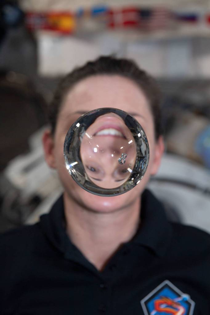 Astronaut Nicole Mann’s image refracts through a sphere of water