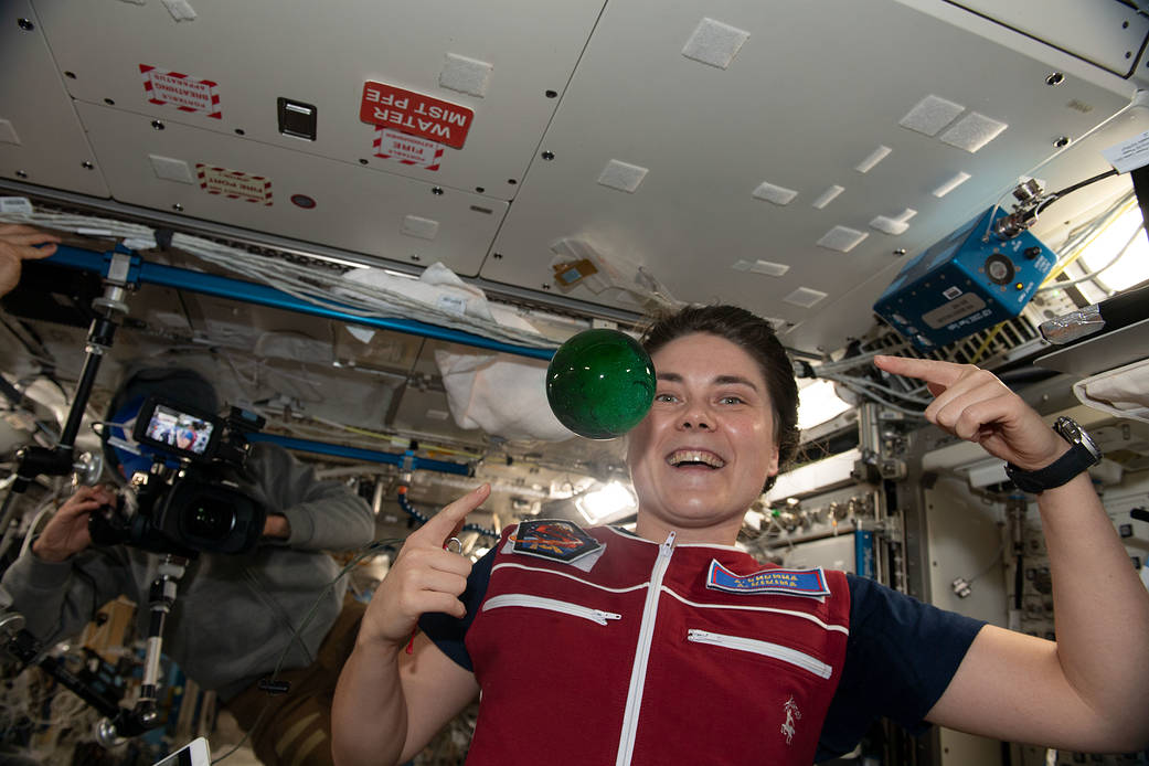 Cosmonaut Anna Kikina plays with a sphere of water flying in microgravity