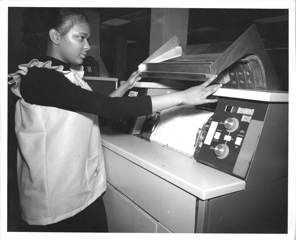 Computer Operator Virginia Baker inspecting data print outs from the UNIVAC 1108 Computer on November 27, 1972. 