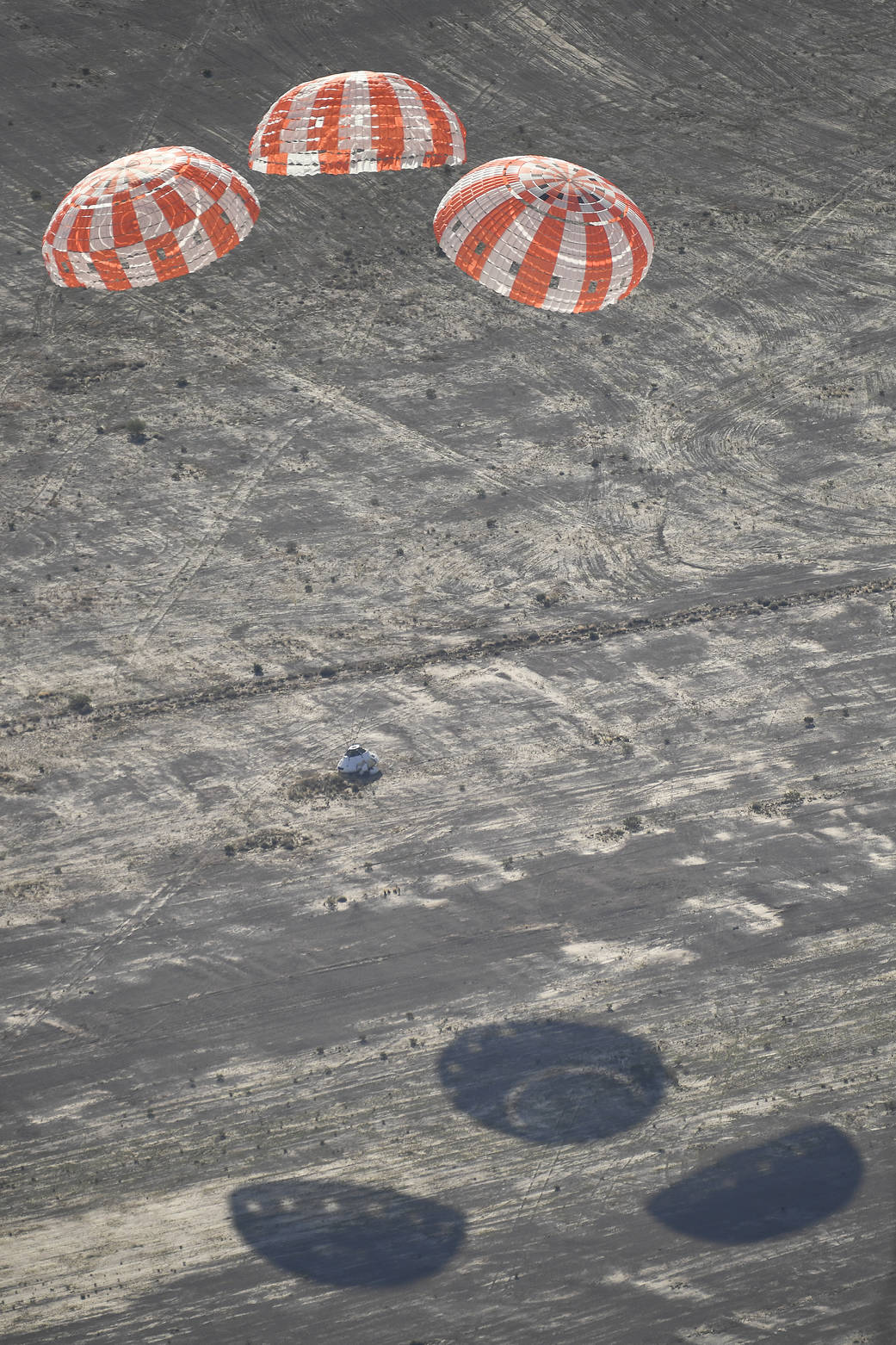 Orion capsule floats to Earth with three parachutes deployed