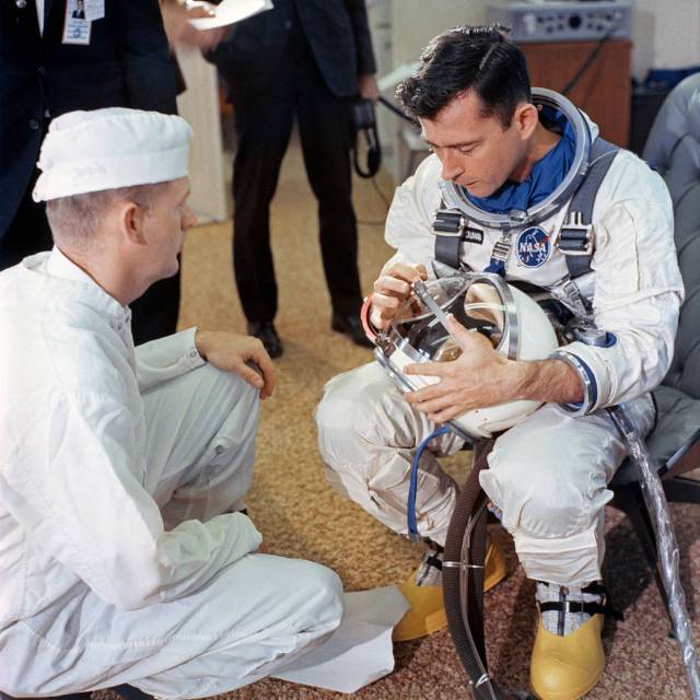 Astronaut John Young inspects his helmet in the ready room in preparation for the launch.