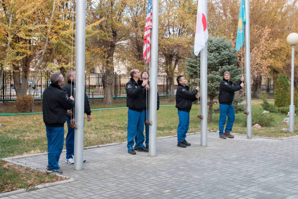 Expedition 38/39 prime and backup crew members participate in the traditional flag-raising ceremony
