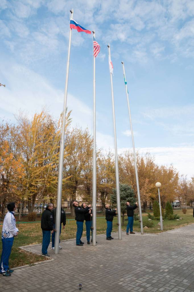 Expedition 38/39 prime and backup crew members participate in the traditional flag-raising ceremony