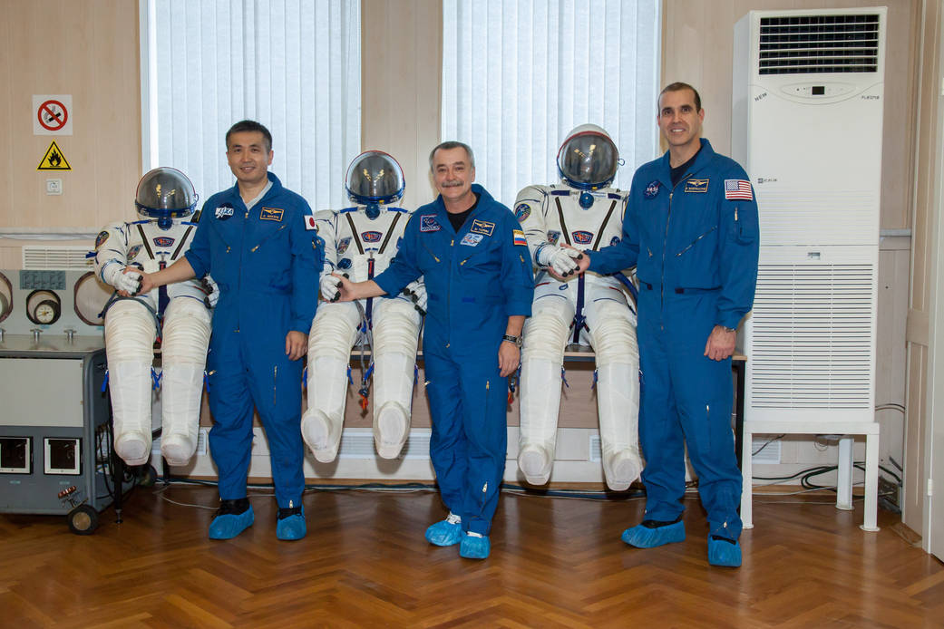 Expedition 38/39 display their Russian Sokol launch and entry suits