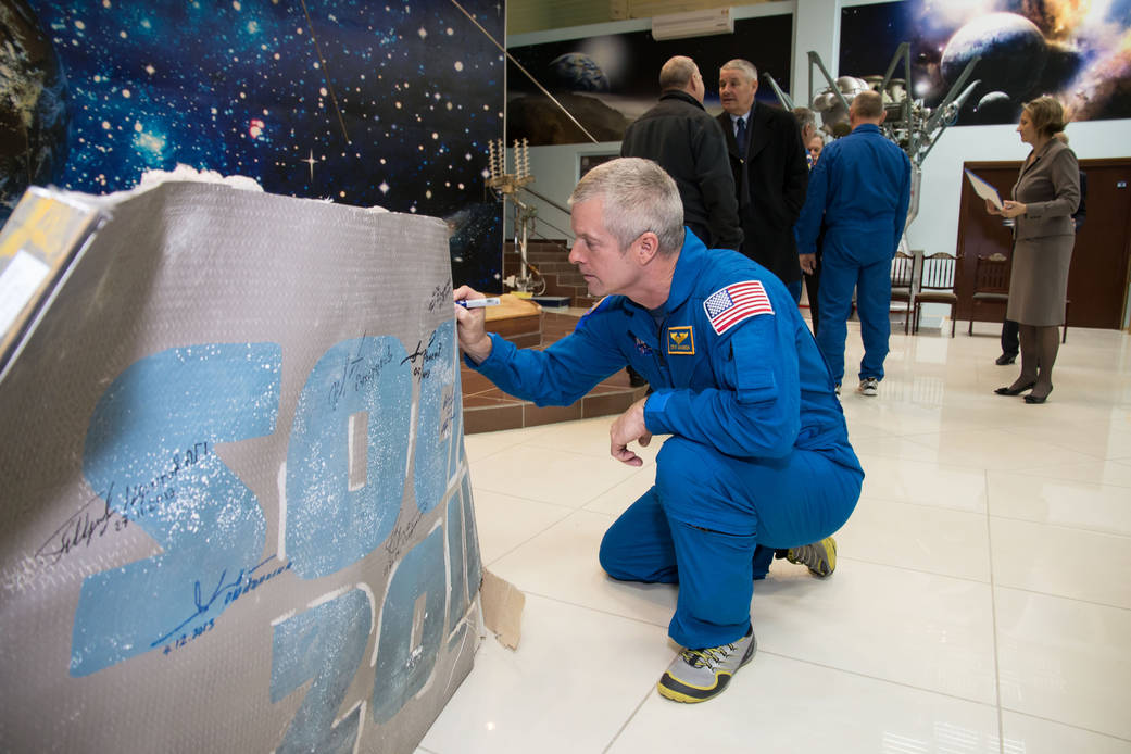 Astronaut Steve Swanson Signs Winter Olympics Banner