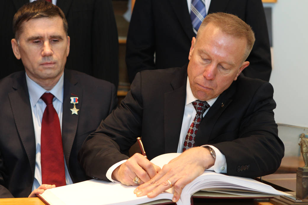 Expedition 46-47 Crew Member Tim Kopra Signs a Ceremonial Book