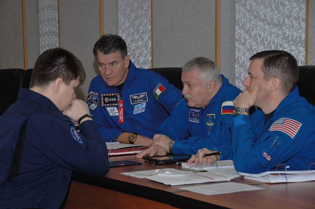 Fischer of NASA (right) review flight plans with trainers Nov. 10 as part of preflight activities