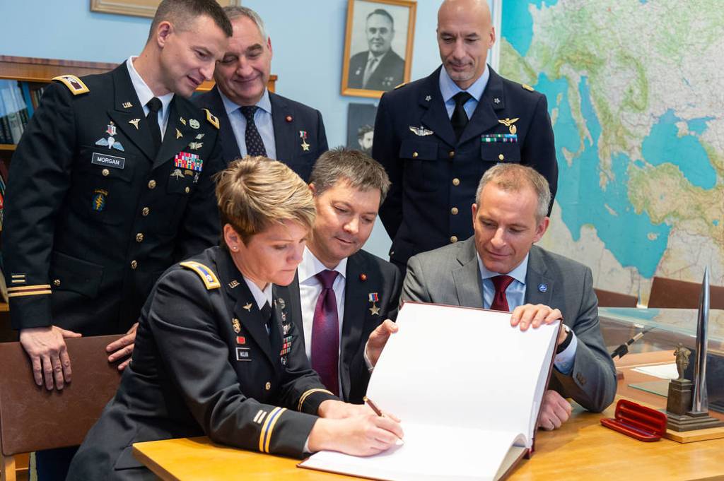 Expedition 58 crew members sign a book in a traditional ceremony