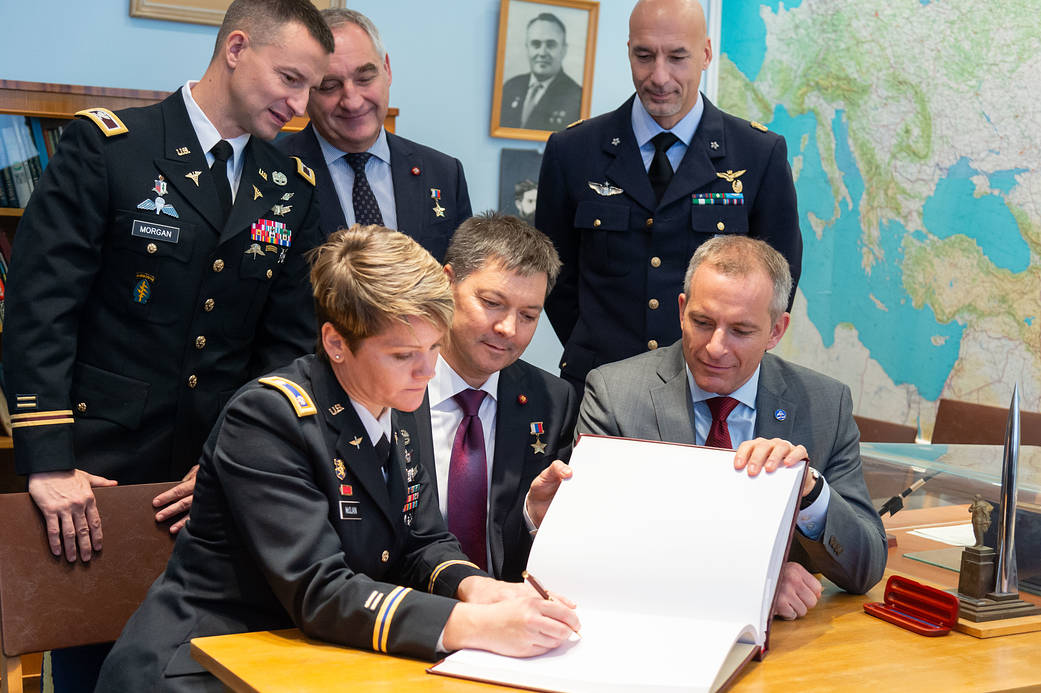Expedition 58 crew members sign a book in a traditional ceremony