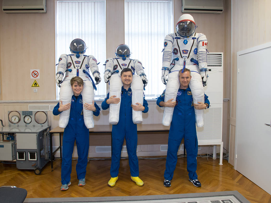 Expedition 58 crew poses with Russian Sokol launch and entry suits