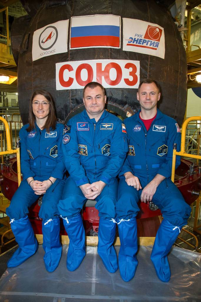 Expedition 59 crew members pose for pictures in front of their Soyuz MS-12 spacecraft