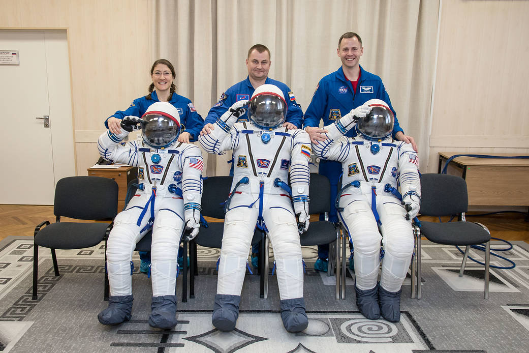 Expedition 59 crew members with their Sokol launch and entry suits